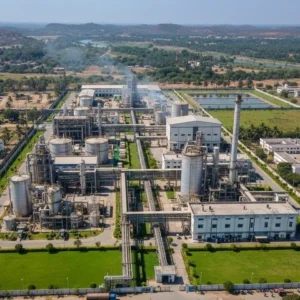 Aerial view of a textile chemical manufacturing plant in India with green lawns, factory buildings, and surrounding landscape. -Top Textile Chemical Companies in India. -1
