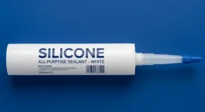 White silicone sealant cartridge with nozzle and cap on blue background, minimal industrial product display, clean lighting. -Industrial Silicone Sealant Suppliers. -1