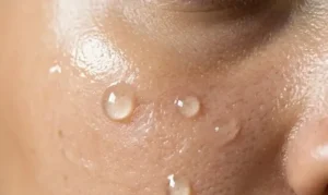 Close-up macro of smooth skin texture with silicone-based serum drops, showing hydration and glossy surface reflection. -Silicones in Skincare. -1