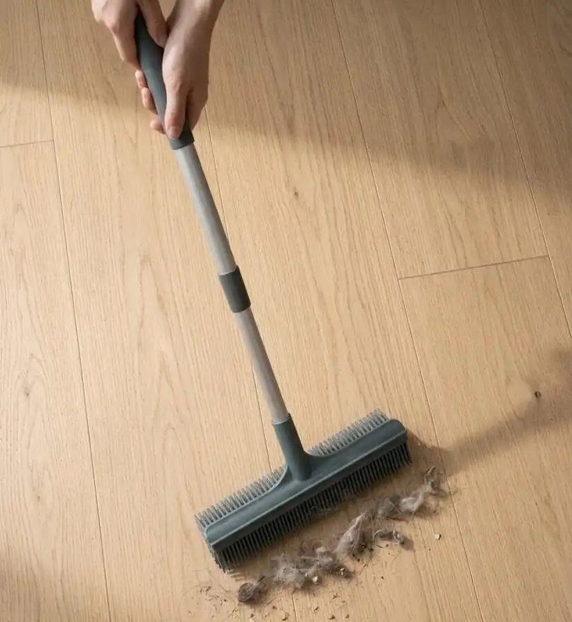 A silicone broom sweeping pet hair on a wooden floor - silicone broom -2