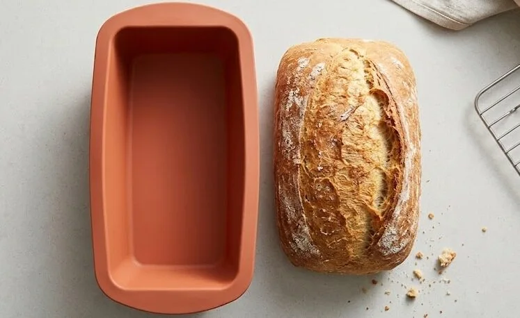 terracotta-orange bakeware next to freshly baked bread - Silicone loaf pan -1