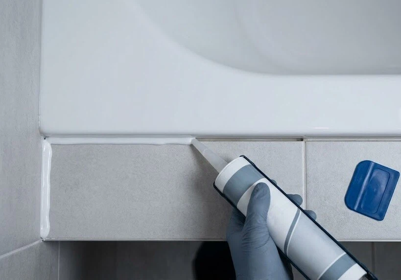 Applying a white bead along a bathtub joint with a nozzle - Bath Silicone Sealant- 2